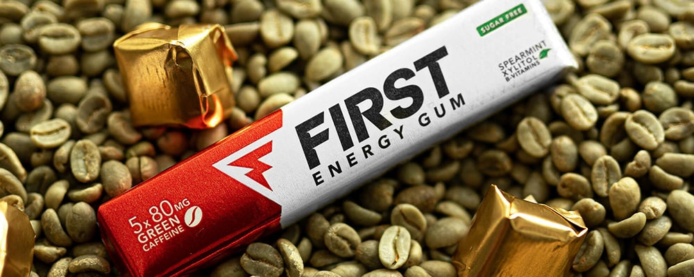 ongeroosterde groene koffiebonen met daarop een pack First Energy Gum